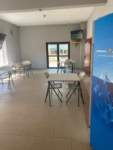 阿克拉Estepona Playa Hostel的一间会议室,配有桌椅和屏幕