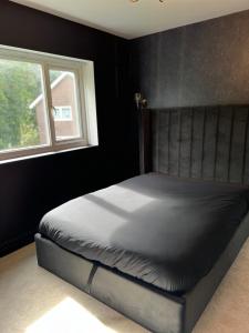 威森肖The hidden cottage的一张位于带窗户的黑色卧室内的床位