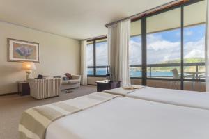 坎普自由鎮佩斯塔纳巴伊亚普拉亚自然海滩度假村的酒店客房设有两张床和大窗户。