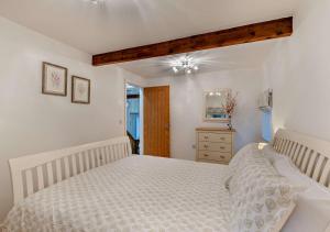 Shotley BridgeHoney Hirst的一间白色卧室,配有一张床和一个梳妆台