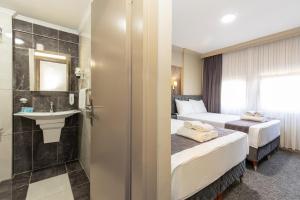 伯萨Loyal City The Best Hotel in Bursa的酒店客房设有两张床和盥洗盆
