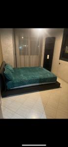 卡萨布兰卡Appartement的一间位于客房内的带绿床的卧室