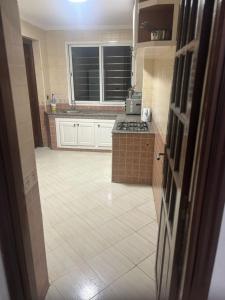 卡萨布兰卡Appartement的厨房配有白色橱柜和瓷砖地板。