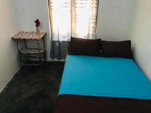 阿鲁甘湾FS Hotel & villa的一间卧室配有一张蓝色的床和一张桌子