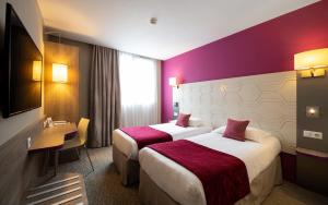 圣马洛圣马洛基里亚德普雷斯蒂奇酒店的紫色墙壁的酒店客房内的两张床