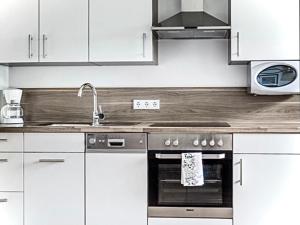 维尔芬翁Alpen Appartements Oberlehengut - HIDEAWAY的厨房配有白色橱柜和不锈钢烤箱
