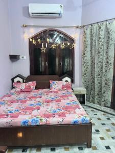 AyodhyaAKG Home Stays的一间卧室配有一张带粉红色棉被的大床