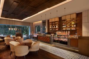 苏拉特Surat Marriott Hotel的一间带桌椅的餐厅和一间酒吧