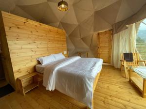 科代卡纳尔L.T NATURE GLAMPS的卧室配有木墙内的一张床
