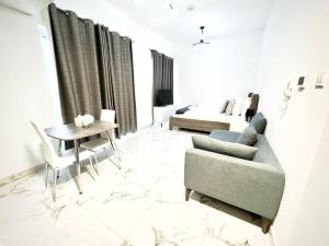 迪拜Mag 5 Spacious studio apartment的客厅配有沙发、桌子和床。
