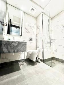 迪拜Mag 5 Spacious studio apartment的浴室配有卫生间、盥洗盆和淋浴。