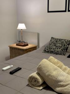卢汉德库约Ocean Apartments的一张带毛巾的床和遥控器