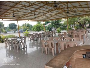 ChāndawāriShreeji Farm and Resort, Jalondar, Gujarat的一组桌子和椅子放在亭子里