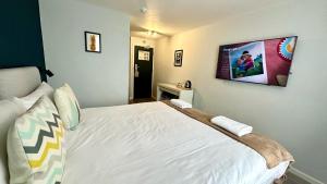 伦敦斯玛特海德公园景旅舍的卧室配有一张白色床,墙上配有电视