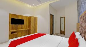 艾哈迈达巴德Hotel Planet Villa的卧室配有一张床铺,墙上配有电视
