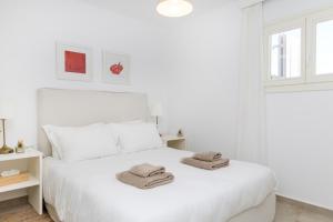 阿里克海滩Naxian Resort的白色卧室配有白色床和毛巾