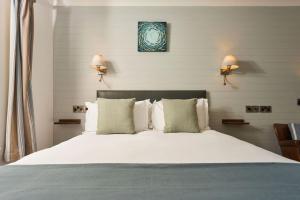 廷塔杰尔威廉港酒店的一间卧室配有一张带两盏灯的大型白色床。