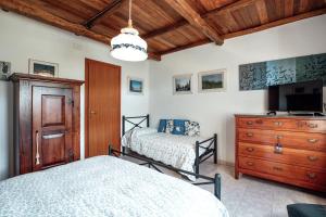 CrispieroSelvicolle Country House的一间卧室配有两张床、一台电视和一个梳妆台。