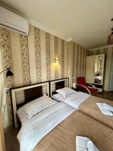 第比利斯Hotel Marioni的一间卧室配有两张床和红色椅子