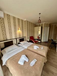 第比利斯Hotel Marioni的两张位于酒店客房的床,配有毛巾