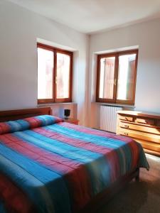乌尔比诺maria antonietta的一间卧室配有一张床、一个梳妆台和两个窗户。