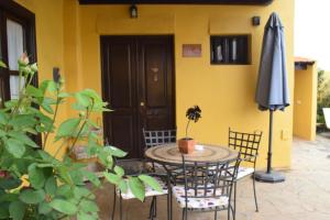 El RosarioGemütliches Ferienhaus in El Rosario mit Privatem Grill und Panoramablick的庭院里配有桌椅和遮阳伞