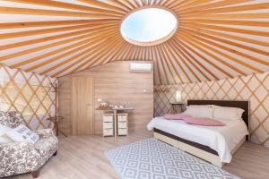 波尔托罗斯提尔格兰品豪华帐篷的蒙古包内一间卧室,配有一张床和一把椅子