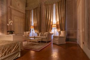 佛罗伦萨奎恰尔迪尼宫殿酒店的一间卧室配有一张床、两把椅子和一张桌子
