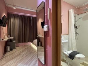 曼谷The Palette Bangkok Hotel的粉红色的浴室设有卫生间和水槽