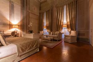 佛罗伦萨奎恰尔迪尼宫殿酒店的一间卧室配有一张床、一张沙发和椅子