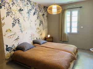 Chatuzange-le-GoubetLe Saint Marin的一间卧室配有一张带花卉壁纸的大床