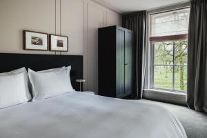 迪温特Pillows Luxury Boutique Hotel aan de IJssel的卧室设有一张白色大床和一扇窗户。