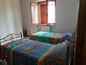 乌尔比诺maria antonietta的一间卧室配有两张带绿色和蓝色毯子的床