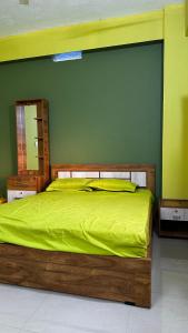 IrikkūrVALIYAVEETTIL INN的一间卧室设有一张木床和绿色的墙壁
