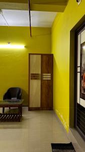 IrikkūrVALIYAVEETTIL INN的黄色的房间,设有木门和椅子