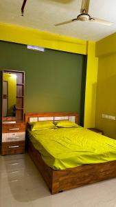IrikkūrVALIYAVEETTIL INN的一间卧室配有一张带黄色床单和镜子的床