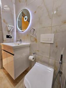 克鲁亚Villa Mefaja的一间带卫生间、水槽和镜子的浴室