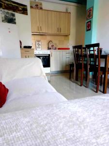 阿里拉斯Arilas Cottage的一间带2张白色床的卧室和厨房