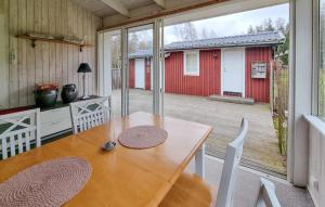 Källby3 Bedroom Pet Friendly Home In Kllby的配有大窗户的客房内的一张木桌和椅子