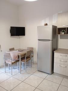 加利波利Sunset home Baia Blu的厨房配有桌子和白色冰箱。