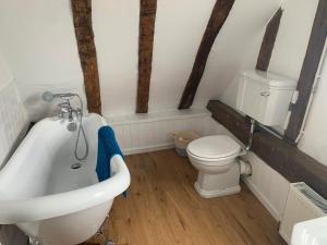 剑桥Beaumont's Cottage的浴室配有卫生间、浴缸和水槽。