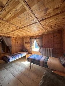 马代西莫Rifugio Teggiate的小木屋内一间卧室,配有两张床