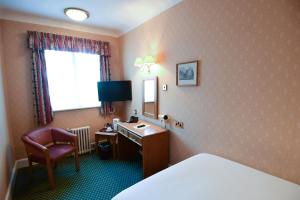 伯恩茅斯The Trouville Bournemouth的酒店客房配有书桌、床和镜子