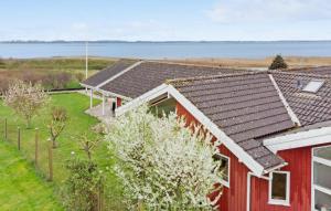 Bogø ByNice Home In Bog By With Wifi的享有水景的红色房屋