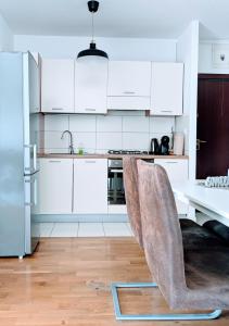 Velika MlakaDoMa-Lu apartment with free parking的厨房配有白色橱柜和桌椅