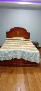 里奥班巴Suite Privada Riobamba的卧室内的一张带木制床头板的床