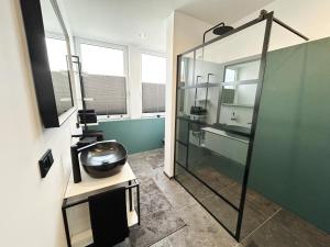 卡塞尔Ferienwohnung Kassel City的一间带玻璃淋浴和水槽的浴室