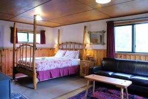 摇篮山Cradle Highlander的一间卧室配有一张床和一张沙发