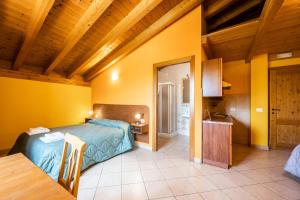 Quinto di ValpantenaAgriturismo il Porcellino的卧室配有一张床铺,位于一个黄色墙壁的房间