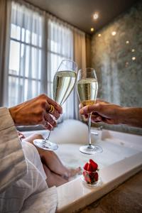 佛罗伦萨Hotel La Scaletta al Ponte Vecchio的两人在床上拿着香槟杯